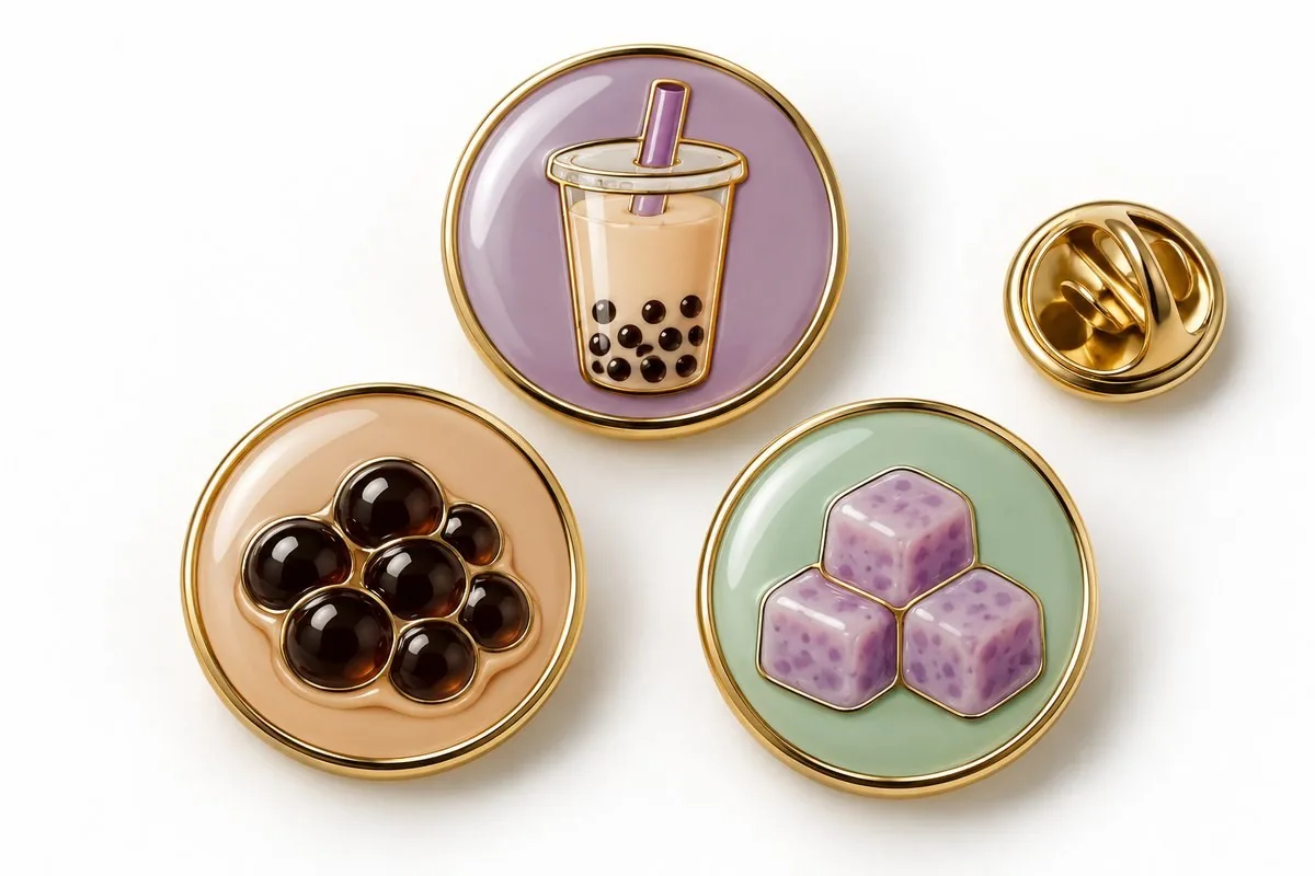 Three enamel badges — cup, pearls and taro